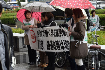 雨が降るなか、横断幕で街ゆく人々に訴えた